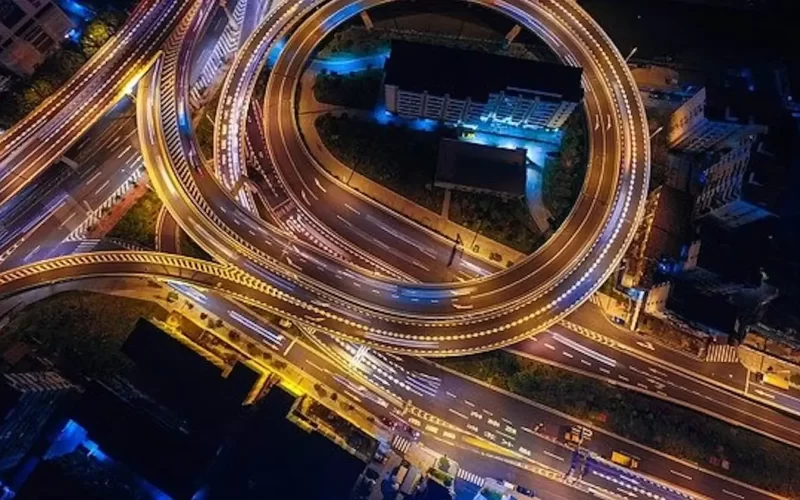 Image of a highway with many exits, covered in lights. The highway conveys a message of having a road to many places that goes with this poem entitles "An Escape"