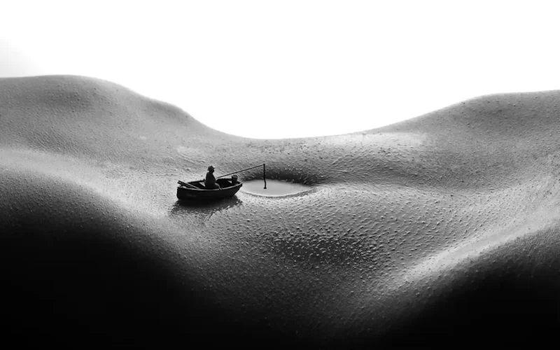 An abstract image of a womans stomach with her navel filled with water and someone in a boat near her belly button, as though on a lake. The image conveys the sensual nature of the poem titled "The visit"