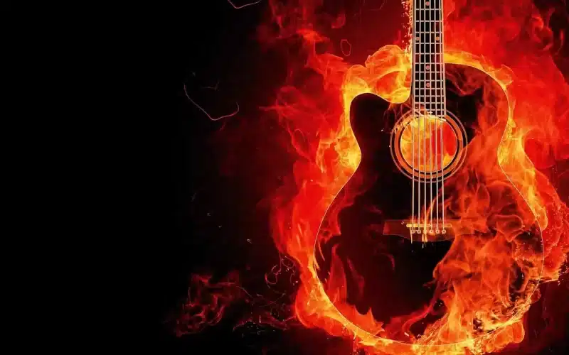 A burning guitar symbolizing passion for music, engulfed in flames against a black backdrop. "Musica è amore" - Music is love.