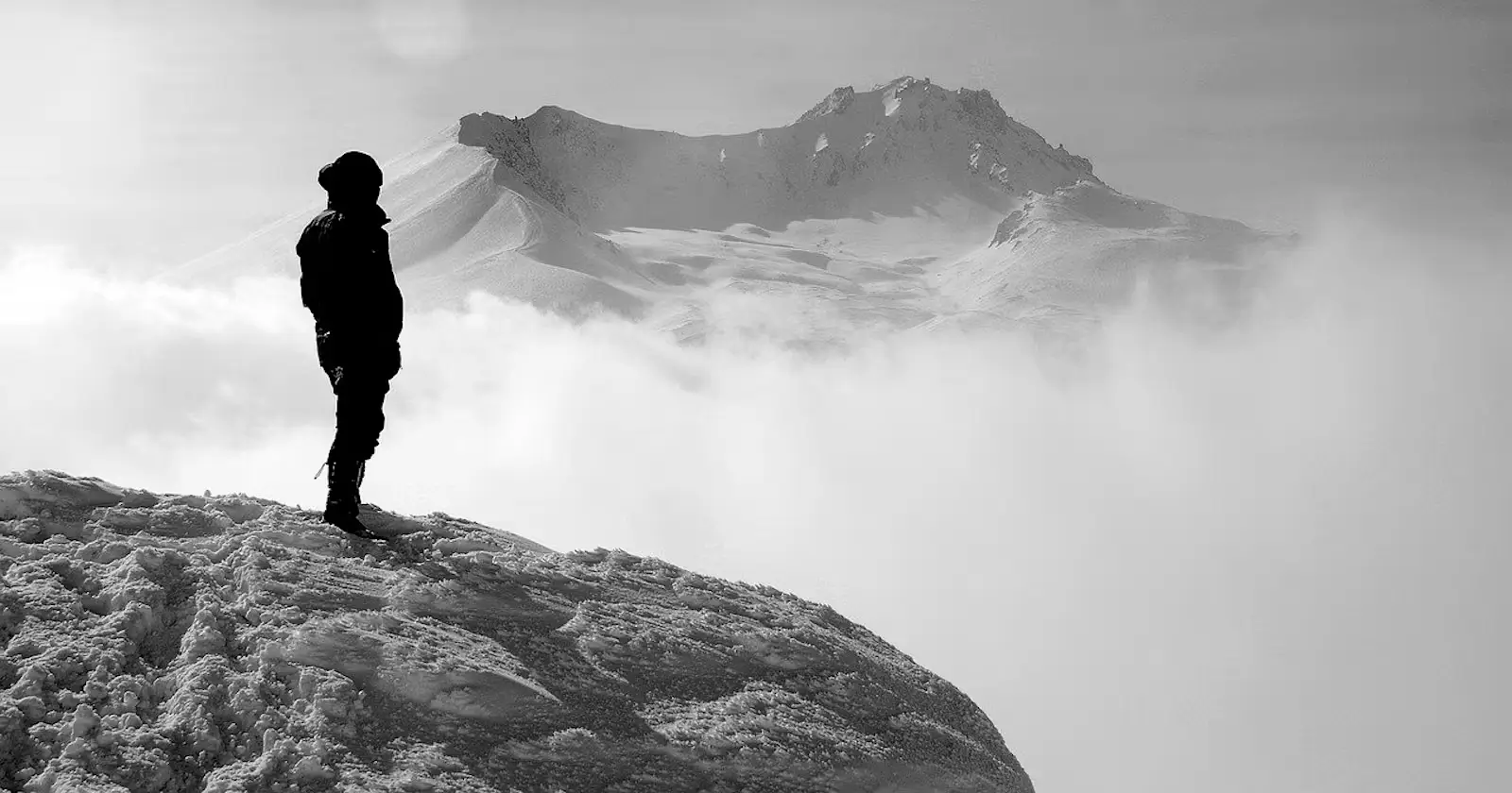 A man on a mountain peak, surrounded by clouds. Majestic view, inspiring heights. Nature's beauty captured in 'Pathways' poem.