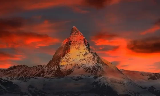 Scenic view of a mountain against a red sky with orange clouds, evoking the essence of a poem Born to Live.