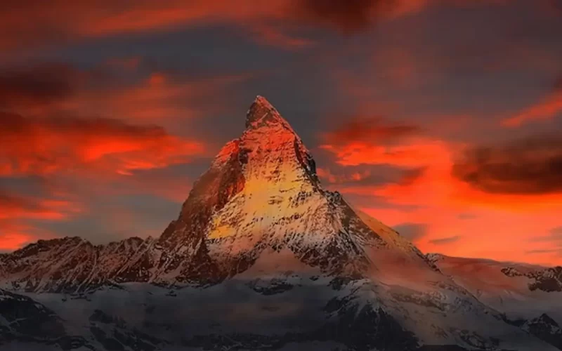 Scenic view of a mountain against a red sky with orange clouds, evoking the essence of a poem Born to Live.