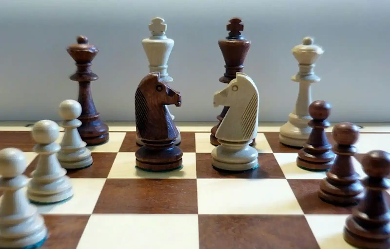 Chess pieces arranged on a chess board, waiting for the next move to be made.