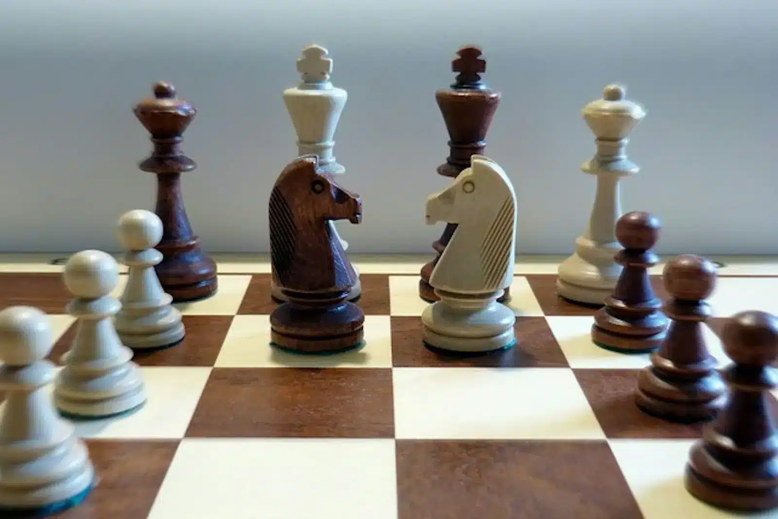 Chess pieces arranged on a chess board, waiting for the next move to be made.