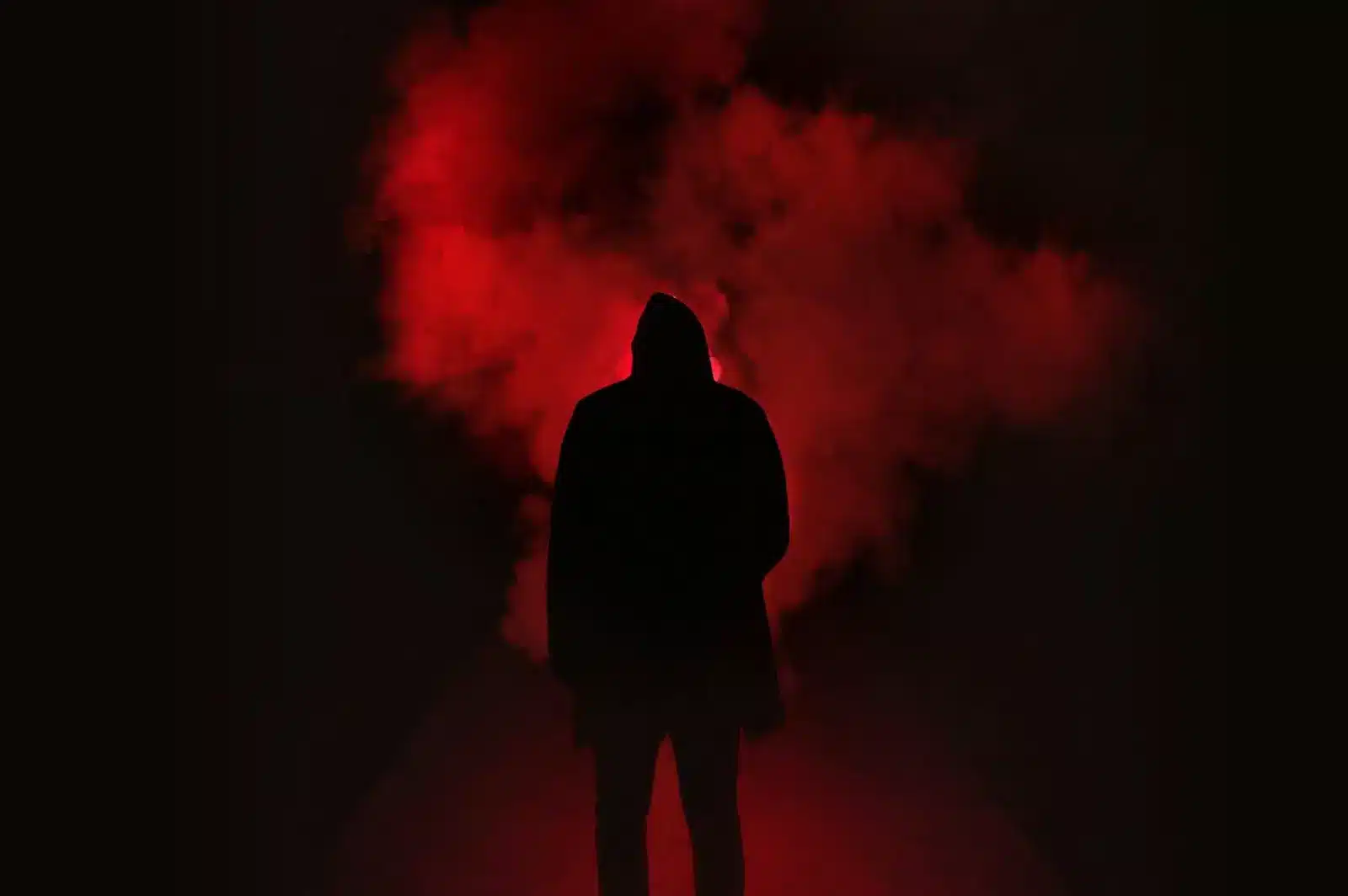 An individual in front of a red smoke cloud, exploring the haunting of my self, finding comfort in seeking understanding.