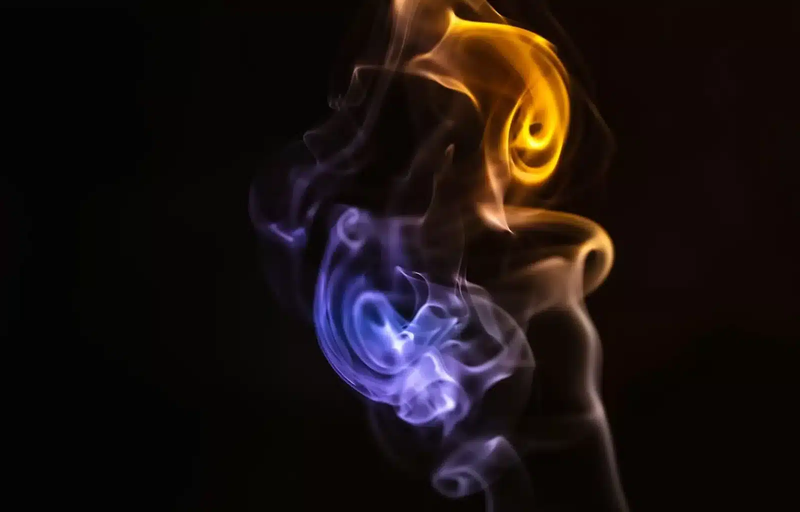A captivating blend of colorful smoke dances on a black canvas, capturing the essence of a shared moment and boundless connection.