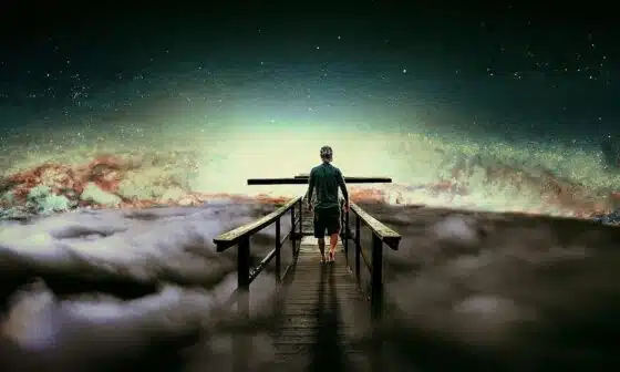 A man standing on a bridge, contemplating life's mysteries under a cloudy sky