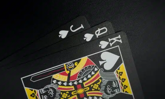 Image of a three playing cards on a black surface. Embrace the unknown, live in the present.