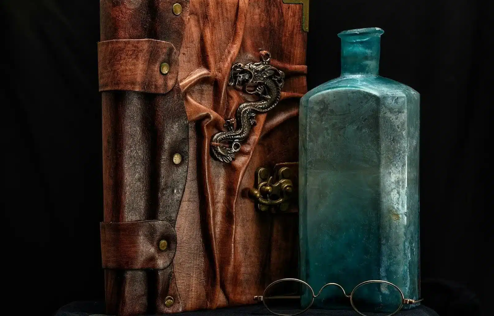 Image of abook, bottle, and glasses on a table.To go along with the story Severed Entanglement: Ritual of Eternal Temptation The Adventures of Griffin and Karen