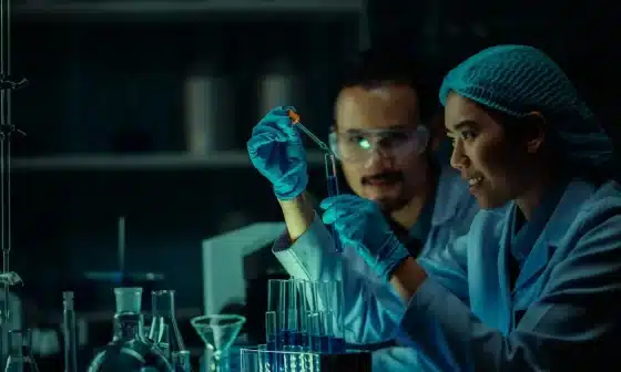 Image of Two scientists in lab coats conducting an experiment with a test tubeto go along with the “Back to the Lab: The Adventures of Griffin and Karen Exp 5
