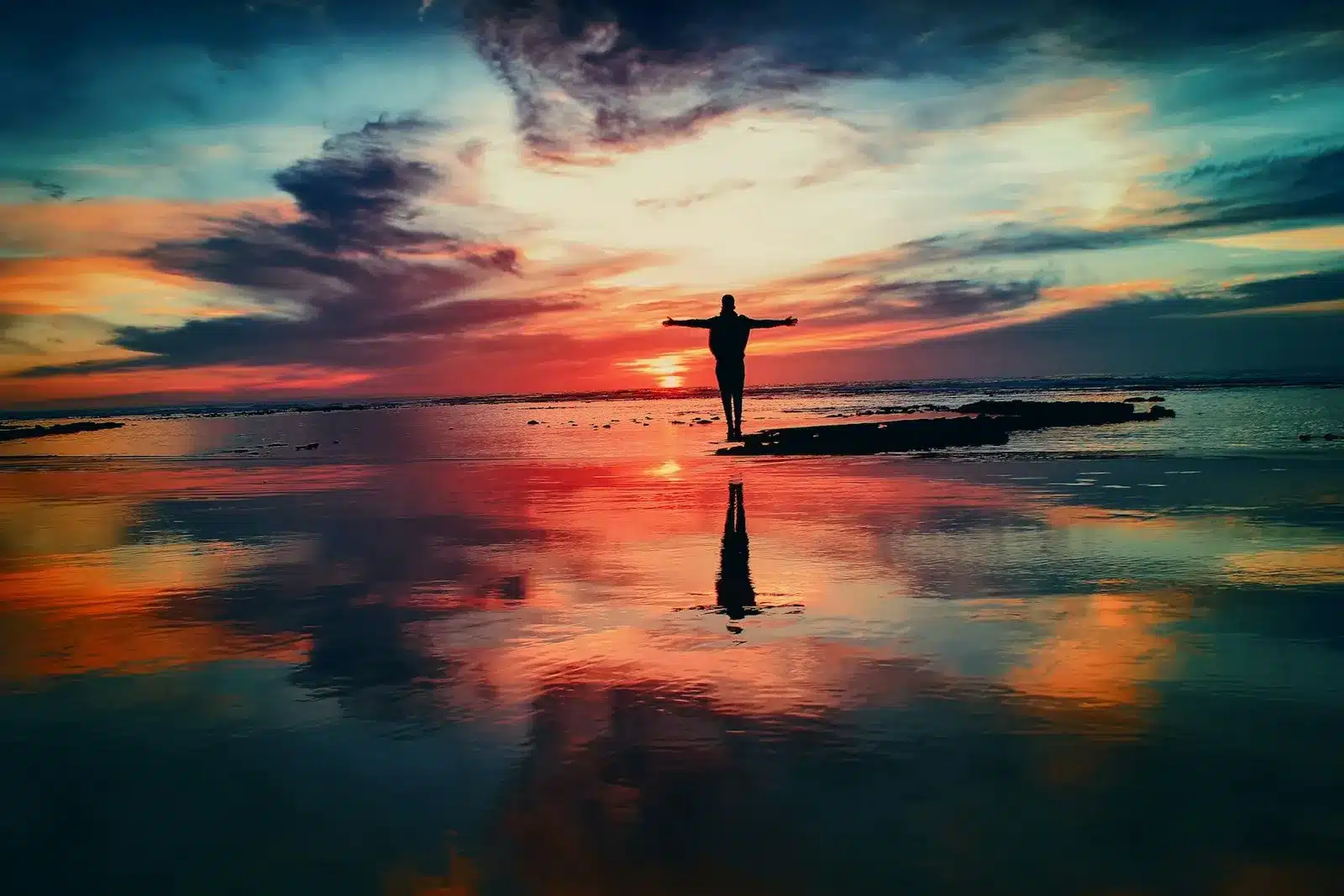 Journey through the Mist: Labyrinth of Self-Epic Poem-A person standing on the beach at sunset, seeking meaning in introspection, confronting masks, embracing vulnerability