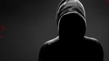 Image of a suspicious figure dressed in a hoodie against a black background, the image accurately depicts what is occurring in this installment of the bloody tulip murder mystery story.