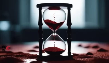 An hourglass with red sand trickling down, casting a blood-like shadow across a table to go along with the theme of Part 11 of the bloody Tulip short story series