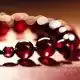 Image of a beaded bracelet with red beads like droplets of blood. This bracelet fits into the narrative of the serial killer thriller Dancing with Darkness: The Bloody Tulip - Part 16